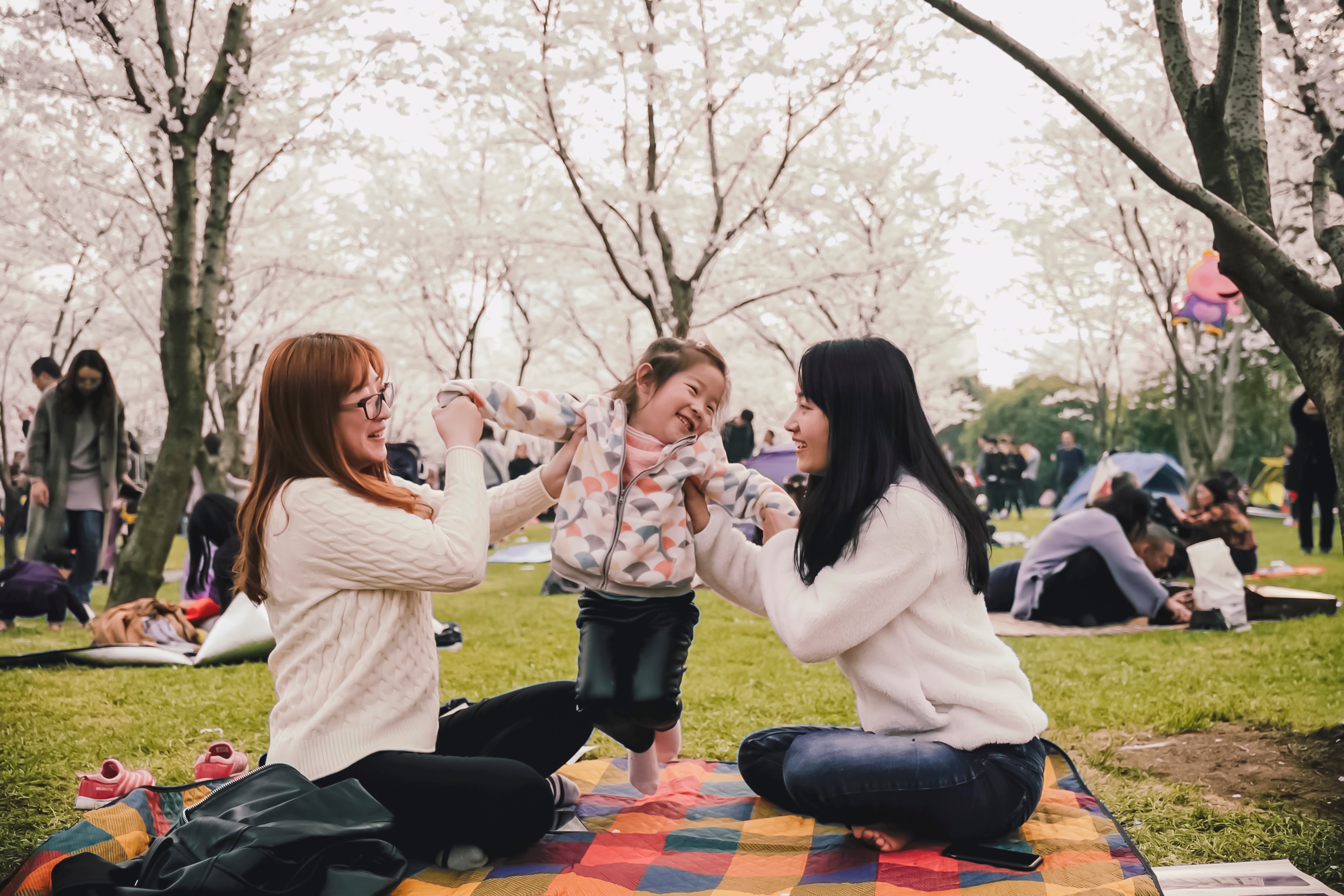 Two adults supporting a child