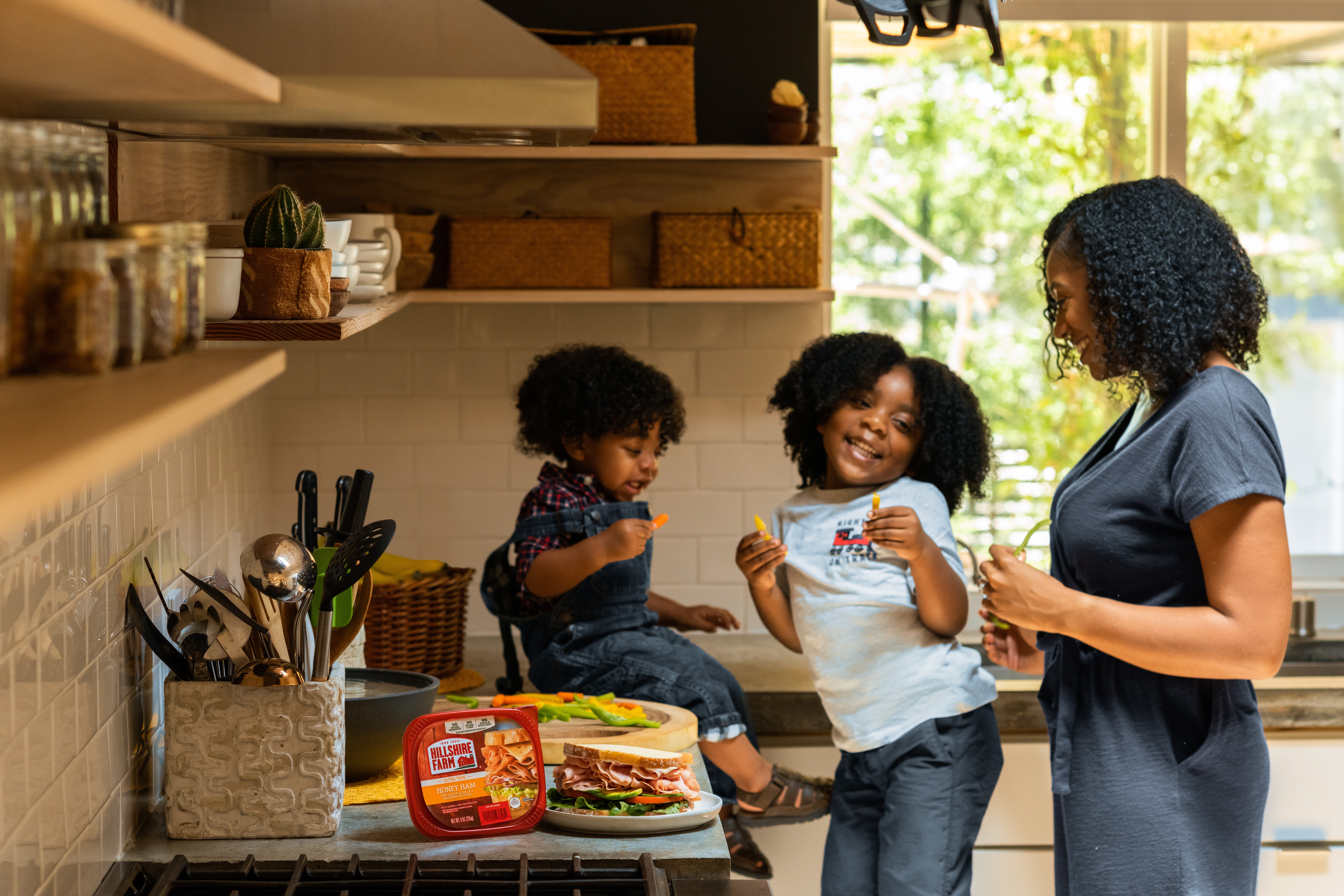 A woman and two children dancing in the kitchen