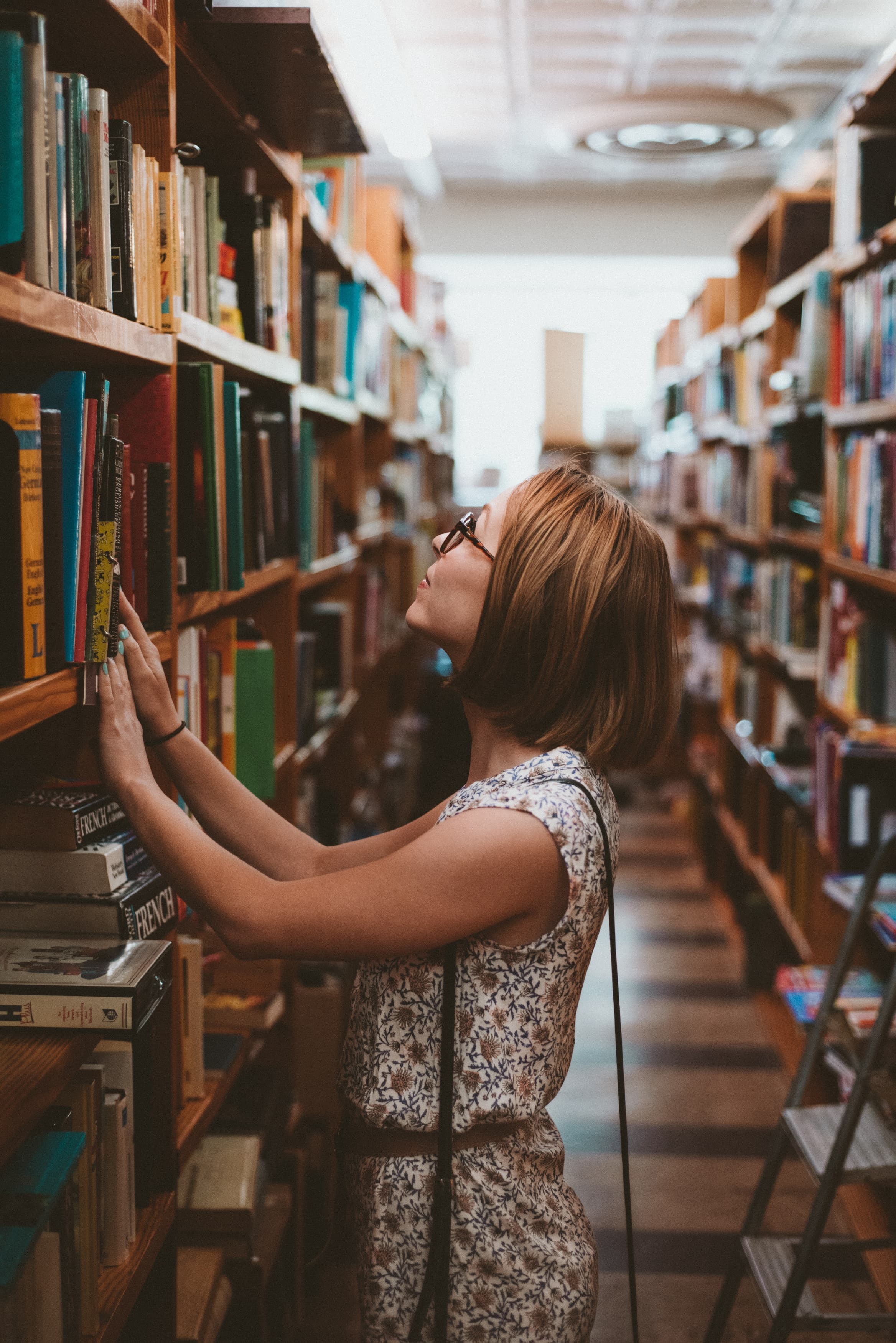 Woman with her hands on a bookshelf in a library