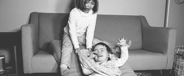 Two children playing by the couch