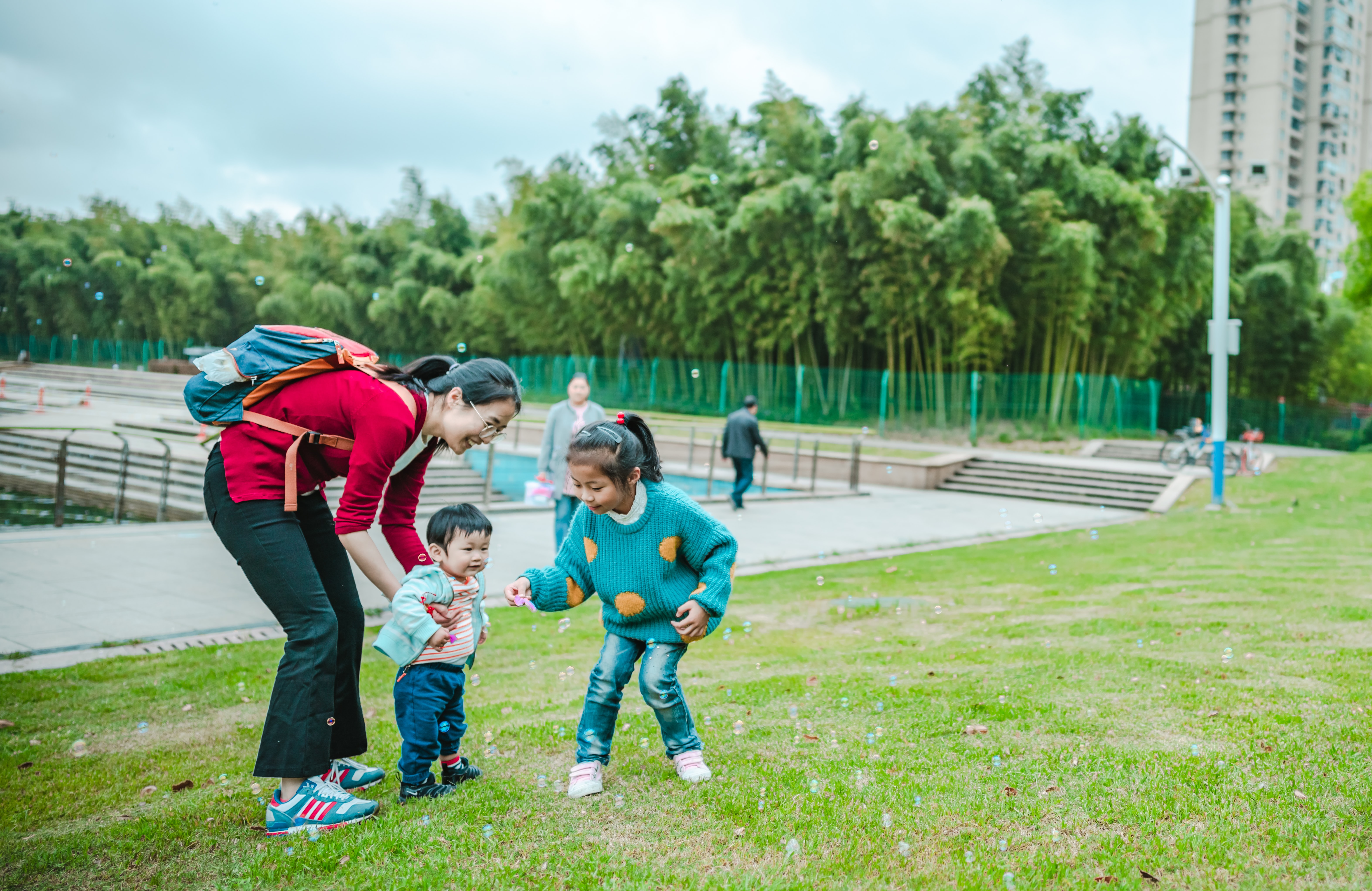 A woman and two children standing on a field 