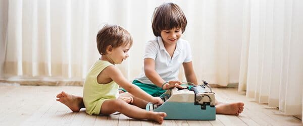 Two children playing with blocks on the floor