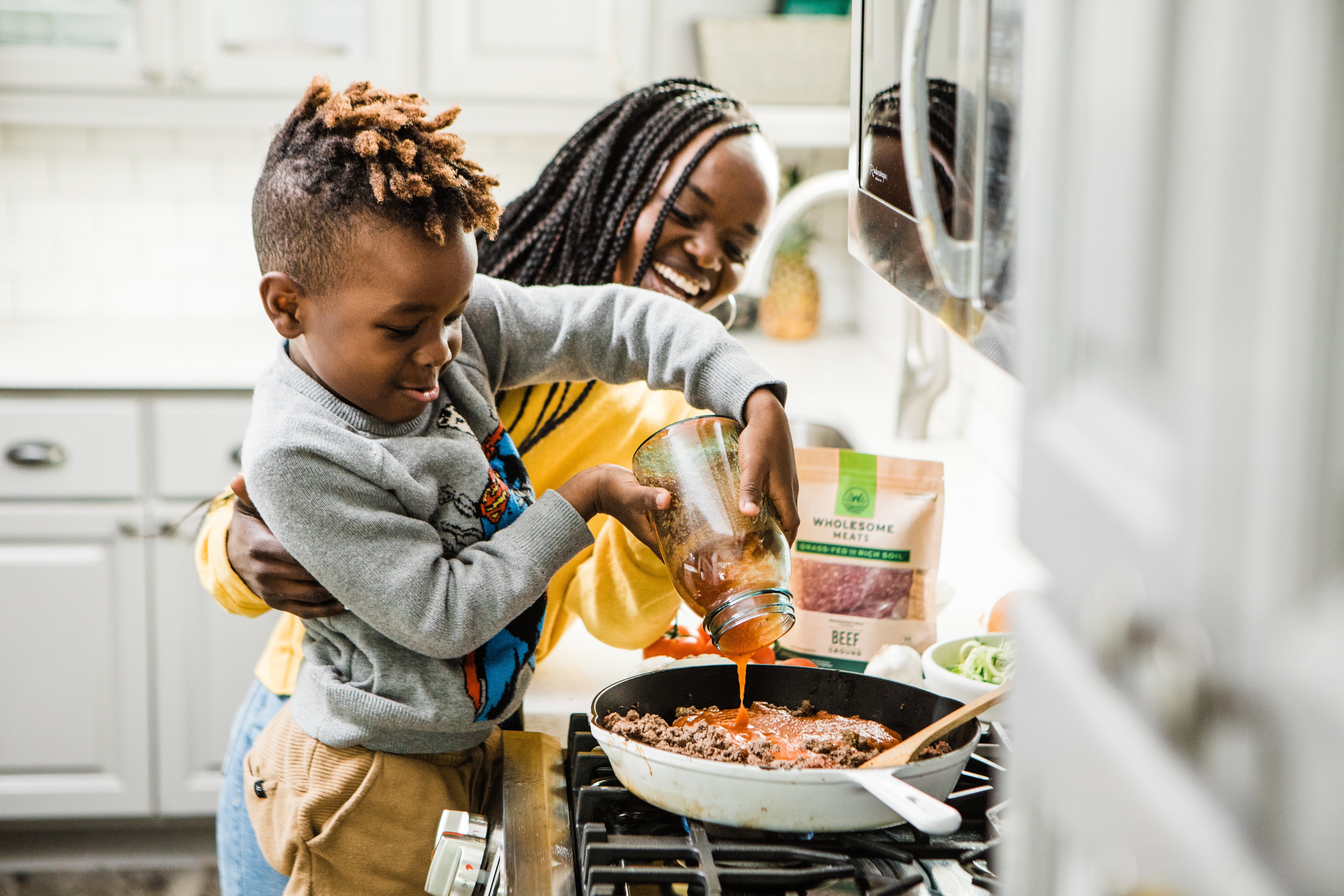 An adult and a child cooking in the kitchen