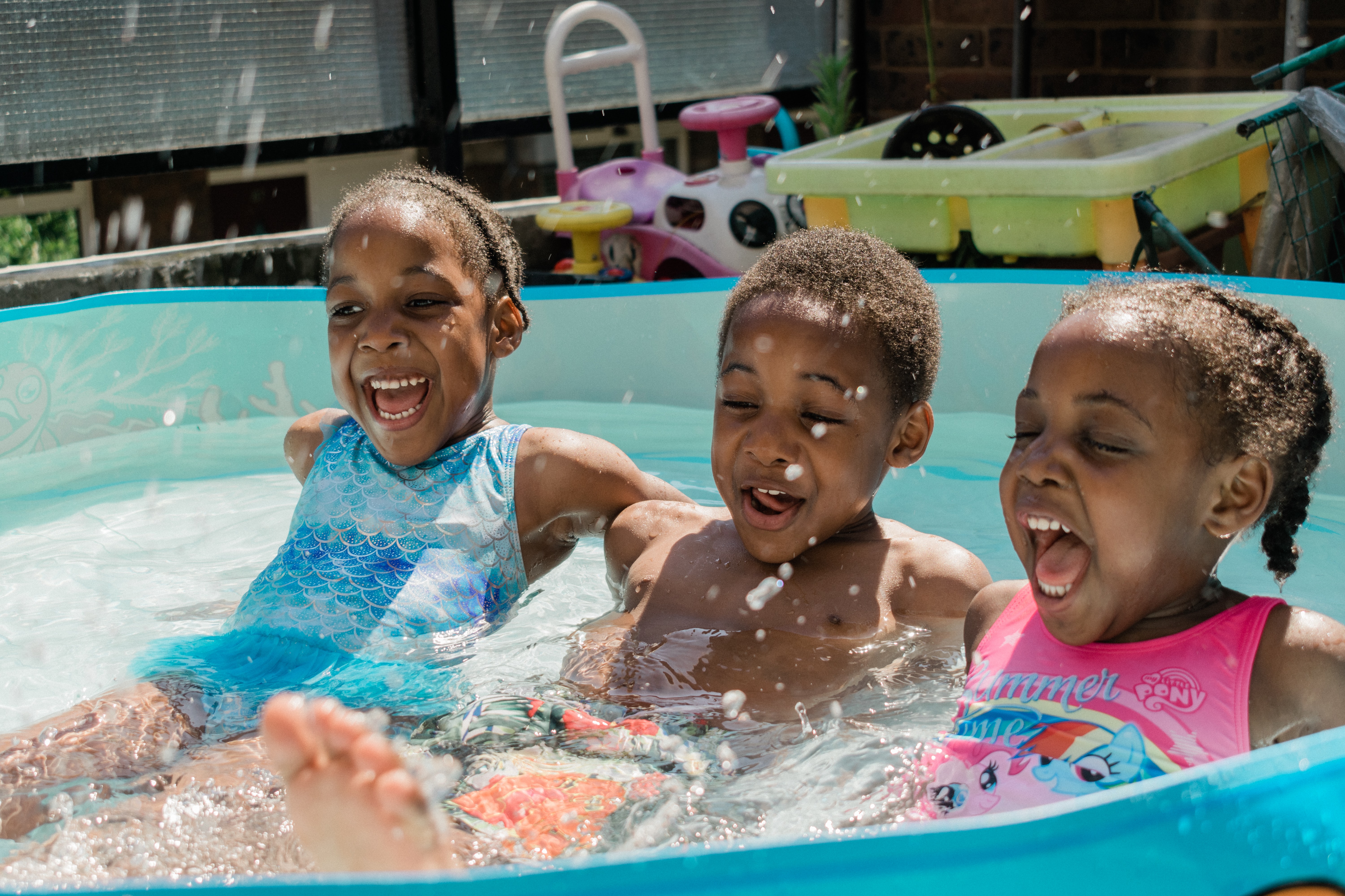 Three children playing a pool