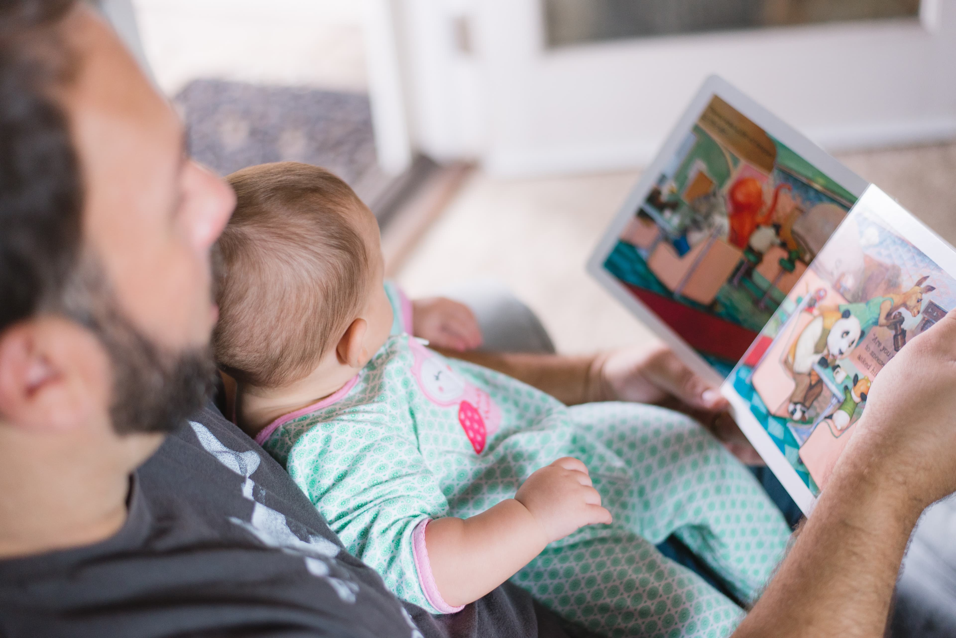 An adult reading to an infant