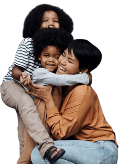 Caring nanny laughing as she hugs two toddlers